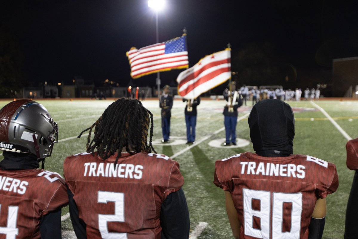 Football players and color guard on the field at night
